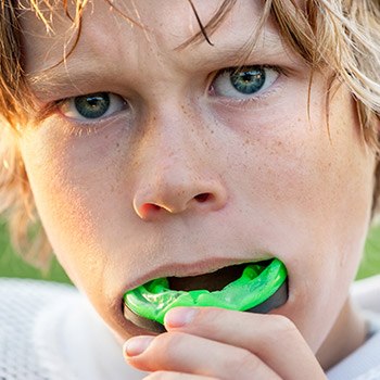 Teen boy placing mouthguards