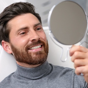 A man smiling at his new dental crown
