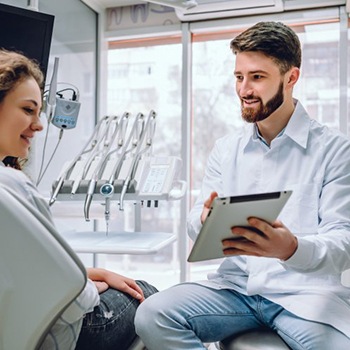 implant dentist in Oak Cliff showing a patient information on a tablet 