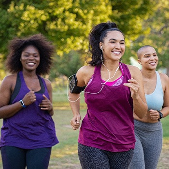 Group of women smiling while jogging in park