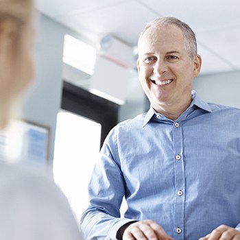 Smiling man checking in at reception desk