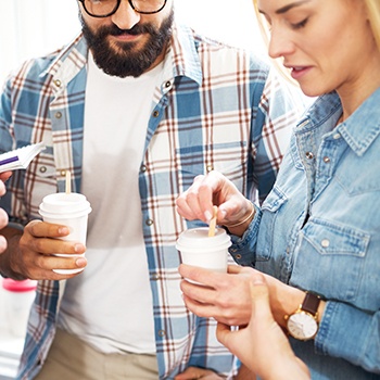 Man and woman holding cups of coffee