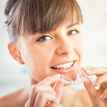 Woman placing Invisalign tray