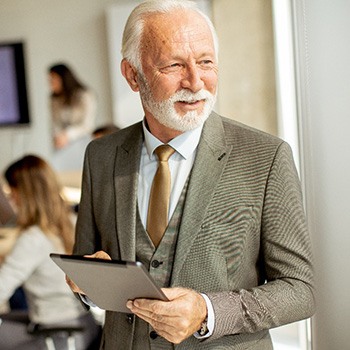 A senior businessman working with colleagues in an office