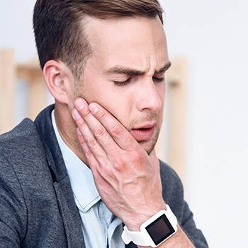 Man holding jaw in pain