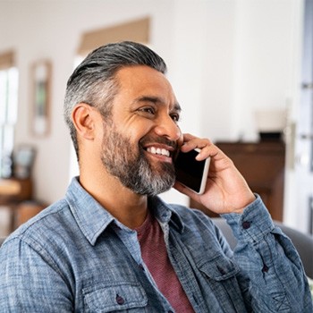 Man smiling while talking on phone