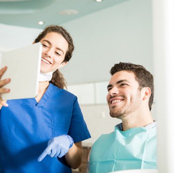 Dentist showing patient image on tablet