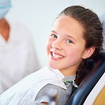 Smiling young girl in dental chair