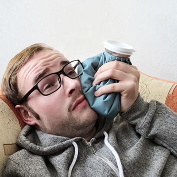 Man resting and recovering from tooth extraction in Oak Cliffs