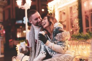 a couple laughing and smiling while outside during the holidays 