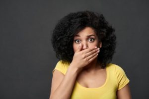 Concerned woman covering her mouth with her hand