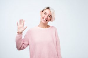 Woman smiles and waves at her Oak Cliff dentist in COVID-19