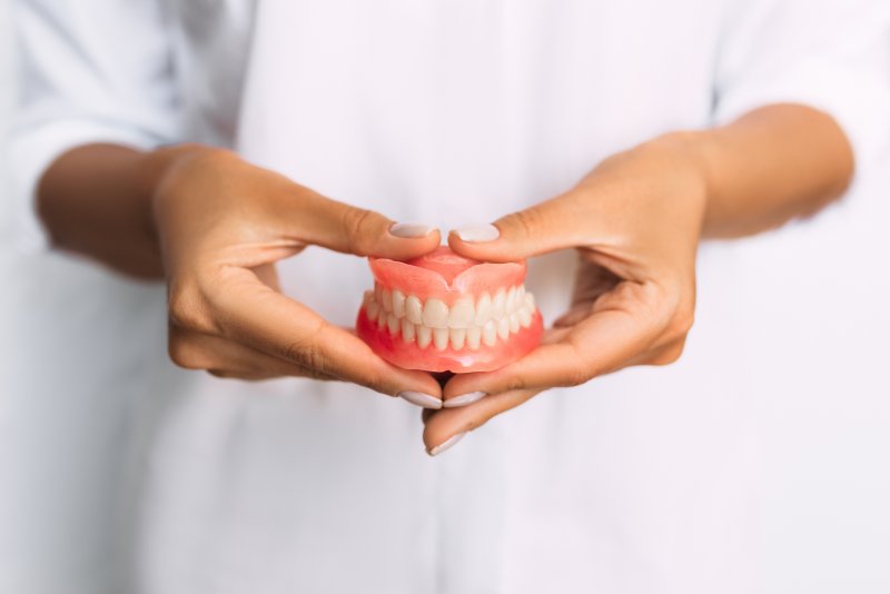 Dentist holding dentures